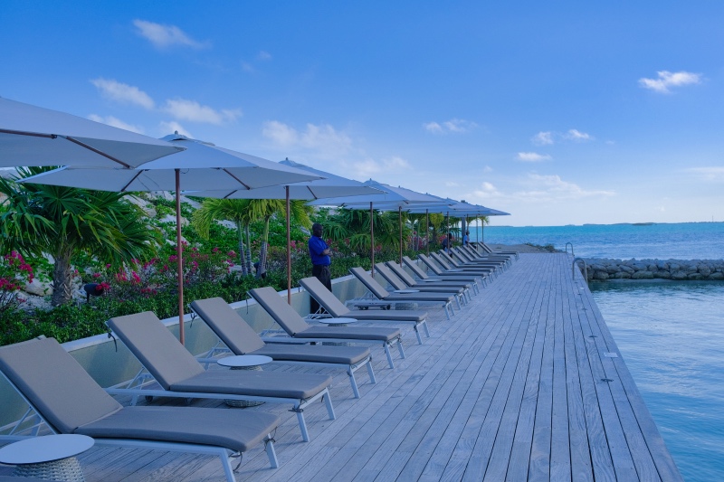 A man attends to the beach chairs overlooking the Caribbean sea in Turks and Caicos.