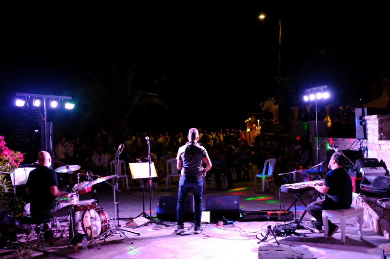 Musicians performing for a crowd in the evening.